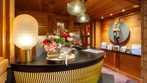 Un mostrador de recepción de madera con un florero, un globo terráqueo y folletos.