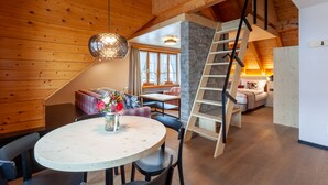 Un interior de madera con comedor, escalera y un rincón de estar acogedor.