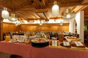 Montaje de bufé con diferentes alimentos y un mantel a cuadros.