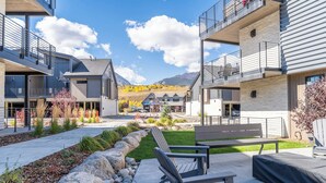 A modern building with outdoor seating and a view of mountains. - River West Condos #714 by Summit County Mountain Retreats (Silverthorne)