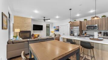 A modern kitchen with a central island, built-in appliances, and pendant lighting.