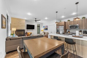 A modern kitchen with a central island, built-in appliances, and pendant lighting. - River West Condos #714 by Summit County Mountain Retreats (Silverthorne)