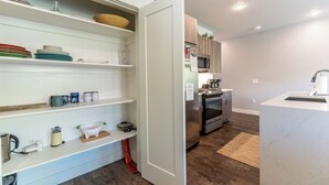 A modern kitchen with white cabinetry, a stainless steel refrigerator, and a built-in microwave. - River West Condos #714 by Summit County Mountain Retreats (Silverthorne)
