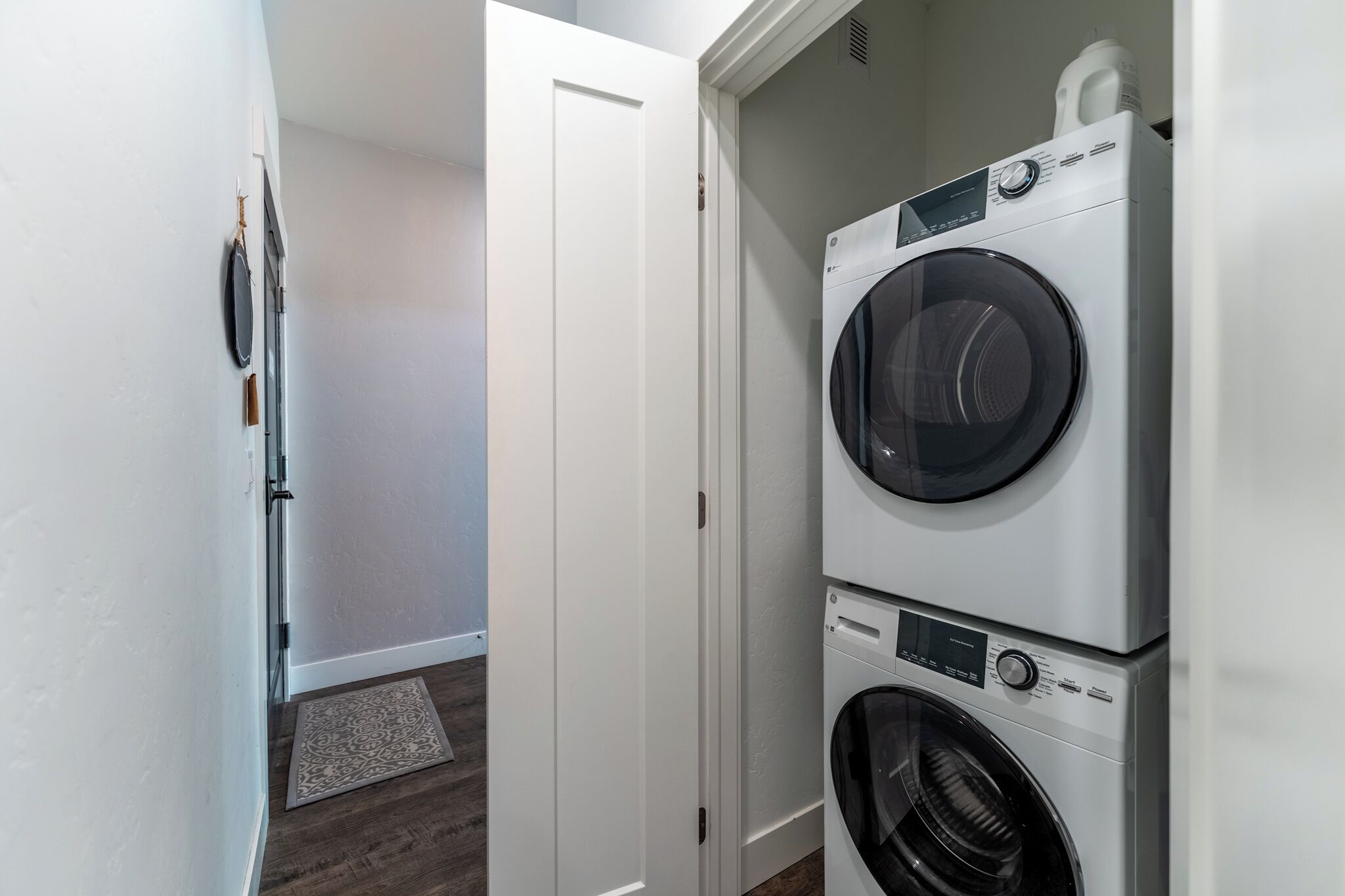 A laundry room with two stacked front-loading washing machines and a dryer.