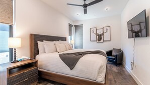 A modern hotel room with a large bed, a ceiling fan, and a nightstand with a lamp. - River West Condos #714 by Summit County Mountain Retreats (Silverthorne)