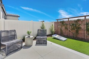 Relax in a serene outdoor space with a seating area, lawn, and lush greenery.