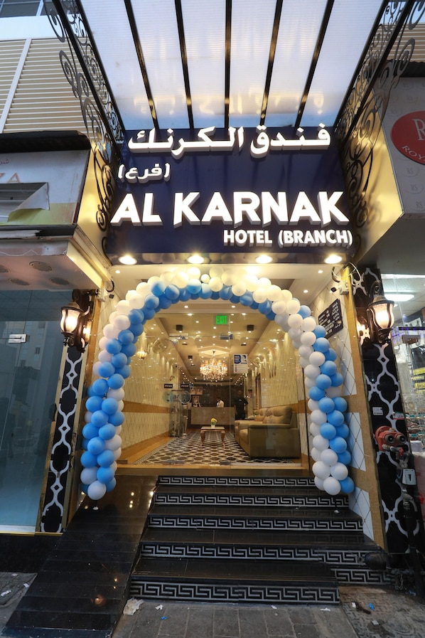 The entrance to Al Karnak Hotel (Branch) with a blue and white balloon archway and a geometric patterned floor.