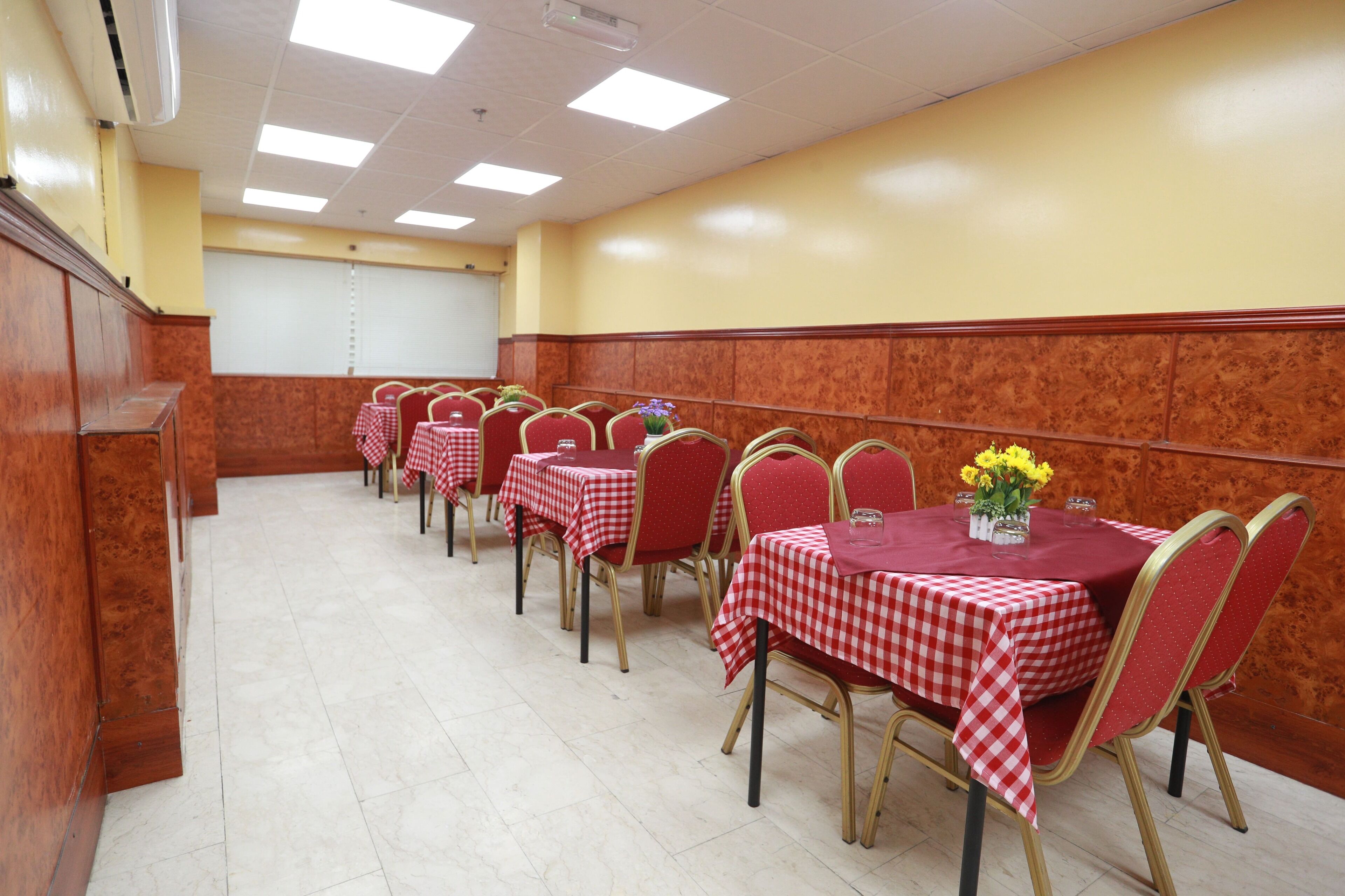 A conference room with multiple tables and chairs, arranged in rows.