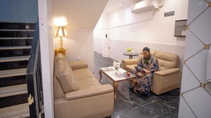 Een moderne hotelkamer met een bank, een bijzettafeltje en een leeslamp.