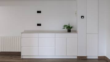 Una cocina moderna con armarios blancos, una encimera y una planta en maceta.