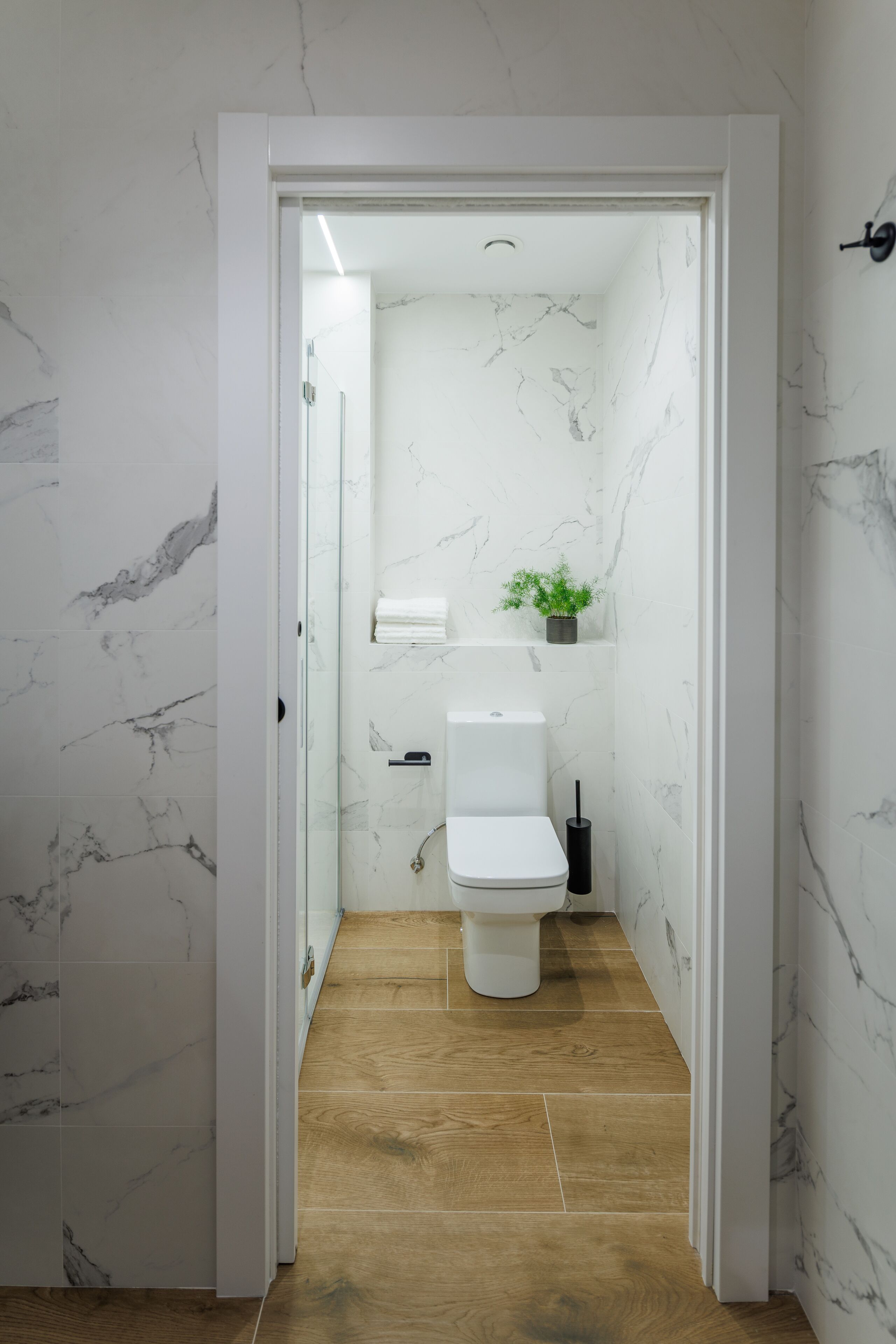 A bathroom with a toilet, a sink, and a shower area.