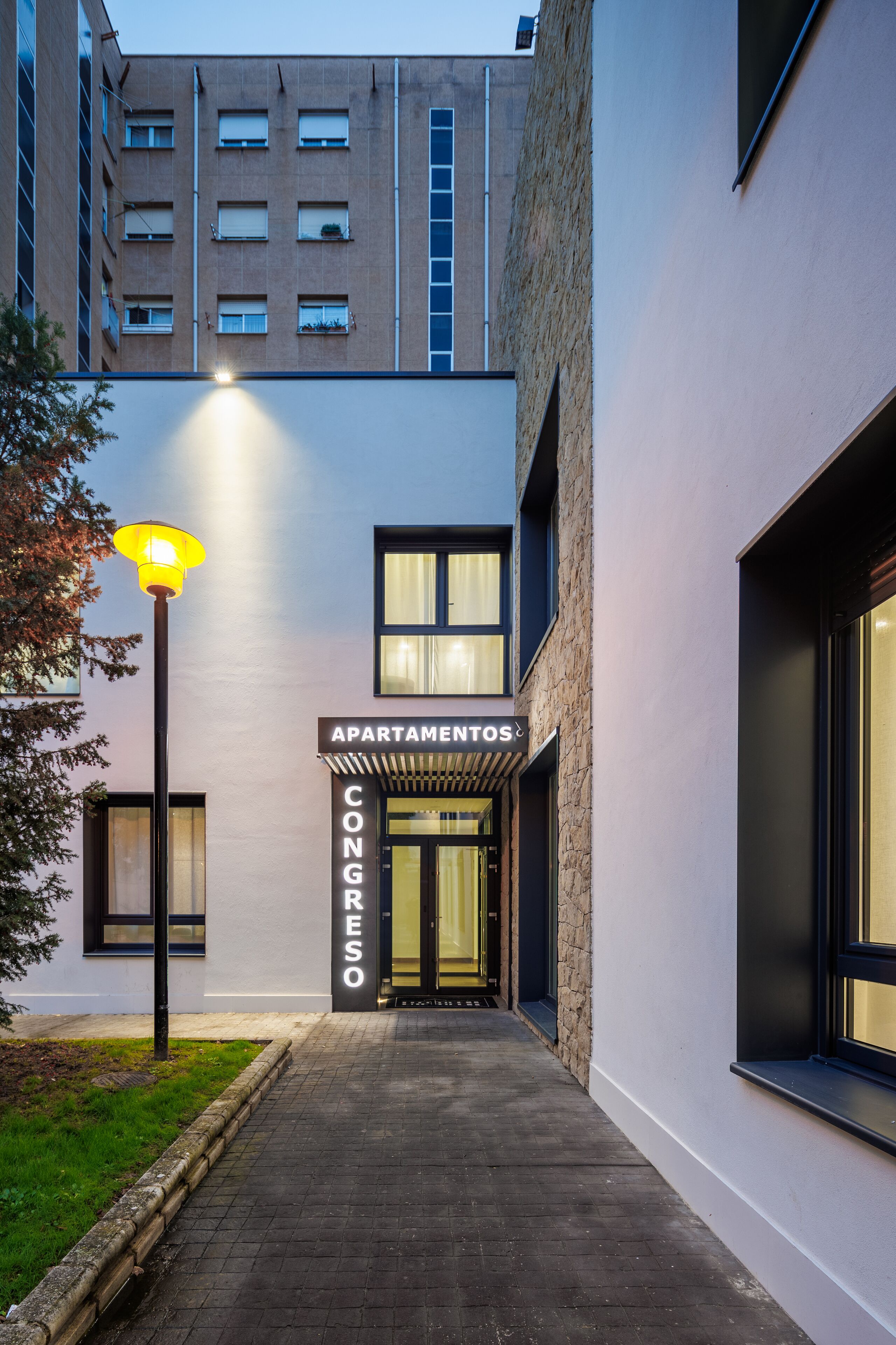 Un bâtiment moderne avec une enseigne indiquant « APARTAMENTOS CONGRESO », ce qui signifie qu’il s’agit d’un centre de conférences.