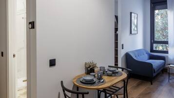 Un espacio moderno de estar con comedor, sofá y ventana.