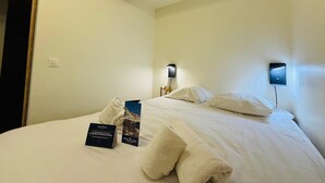 Ein Hotelzimmer mit Bett, zwei Nachttischen und einem Holzbalken an der Decke.