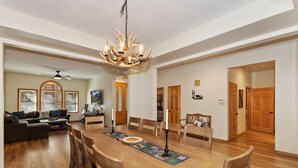 Ein geräumiger Essbereich mit Holztisch, Stühlen und einer Chandelier.