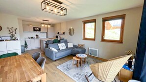 A modern living space with a kitchen, dining area, and seating area. - 3* Chalet Valmorel, ski-in/ski-out, 3 bedrooms, parking, WIFI (Valmorel)