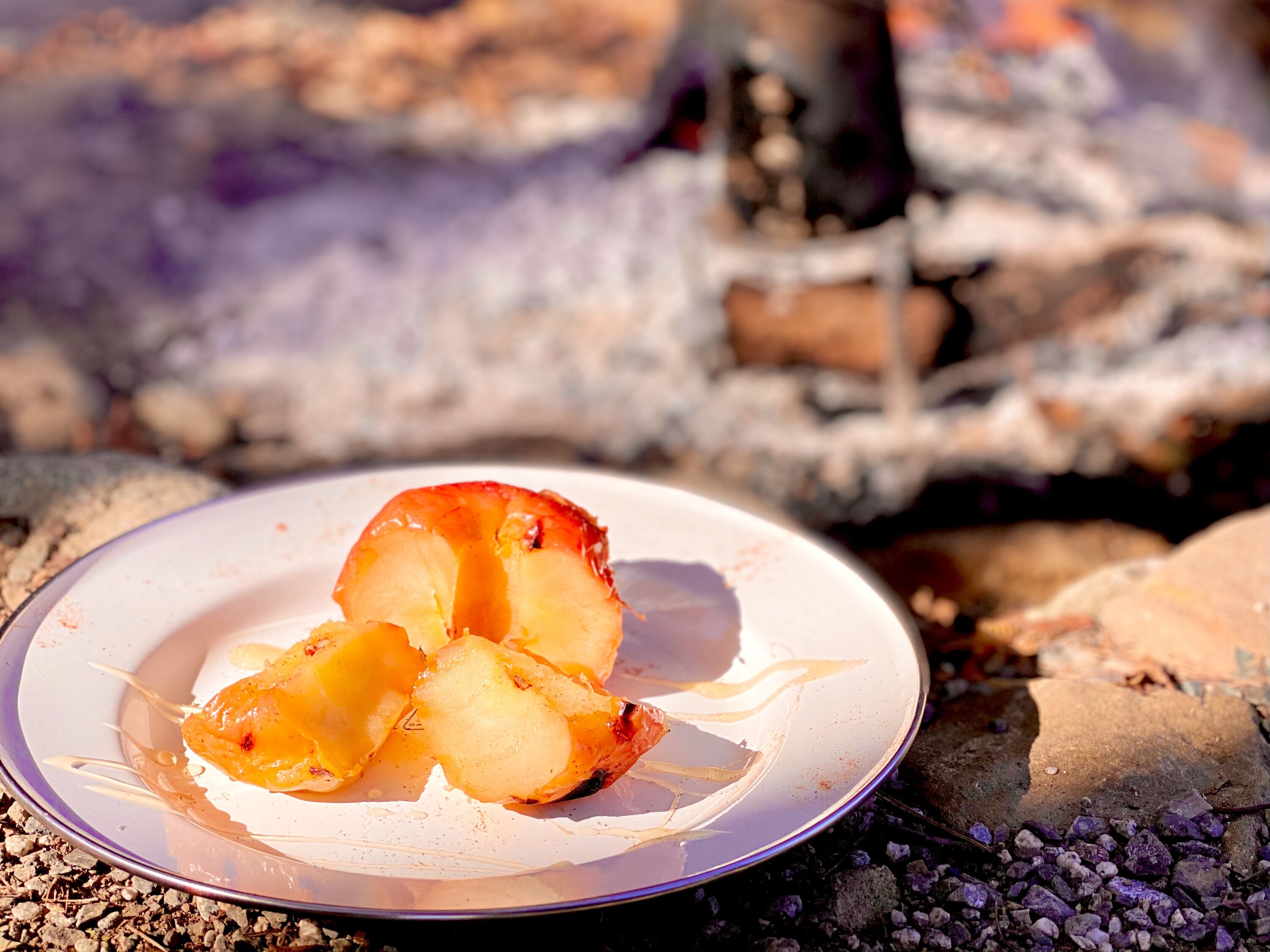 A plate with a partially eaten peach on a white plate.