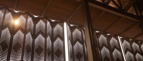 A series of vertical panels with geometric cut-out patterns, likely part of a building's interior design.