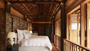 Ein Schlafzimmer aus Holz mit einem Bett, Nachttischen und einem Balkon.