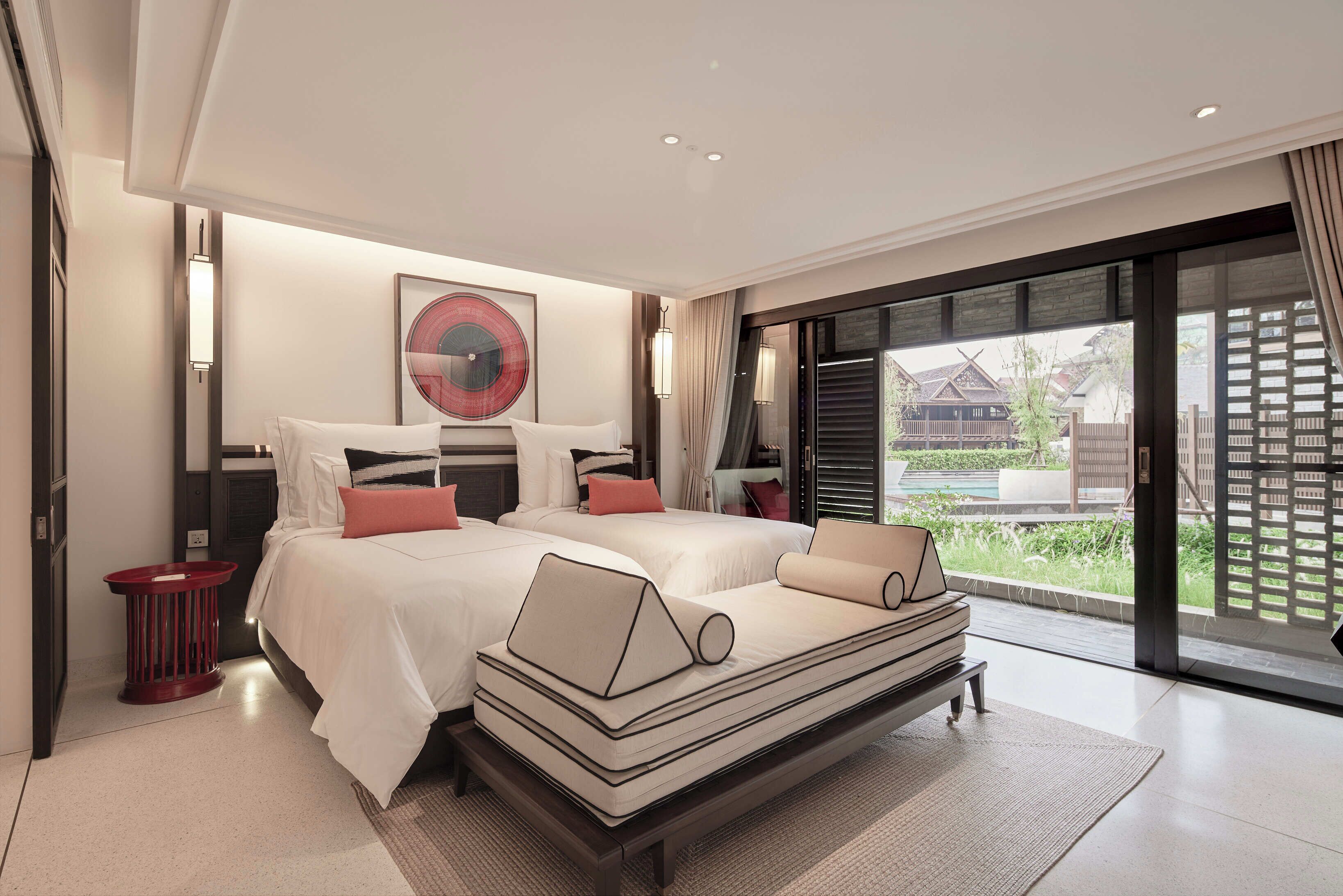Une chambre d’hôtel moderne avec un grand lit, une table de chevet et une vue sur l’extérieur.