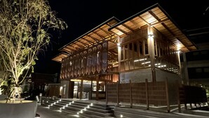 Ein modernes Gebäude mit Holzfassade, großen Fenstern und einer Treppe, die zum Eingang führt.