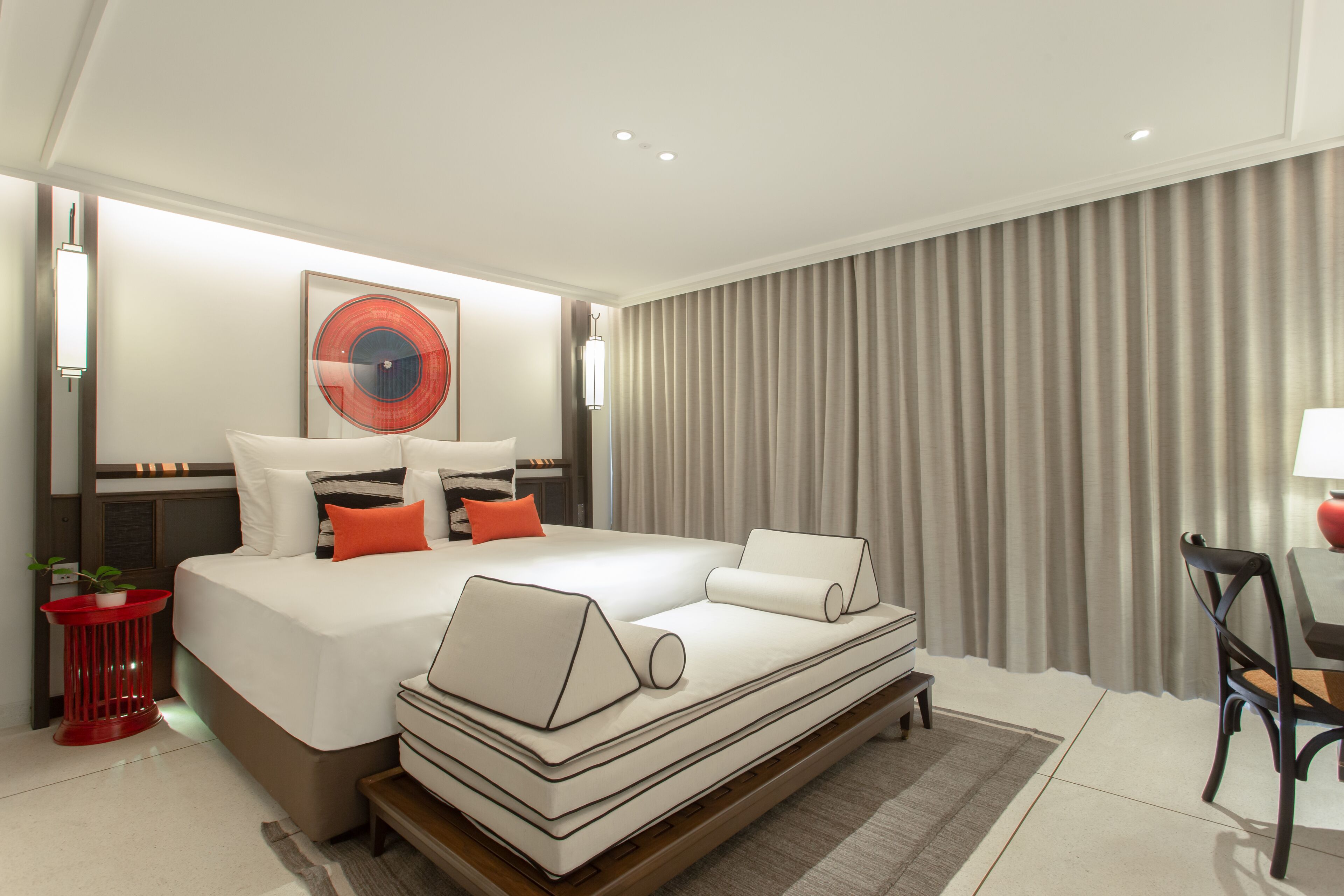 Una habitación de hotel moderna con una cama grande, un escritorio y una silla.
