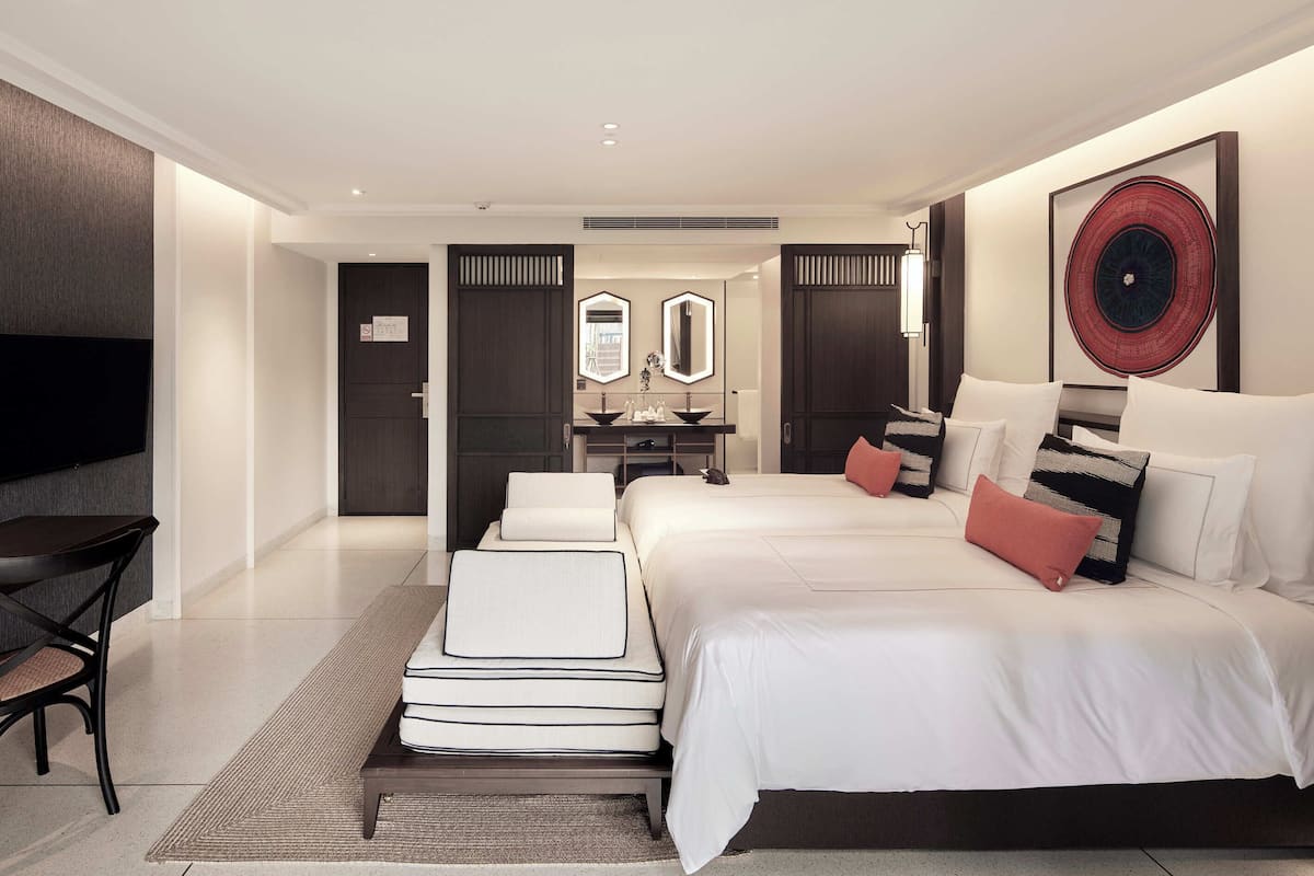 Een moderne hotelkamer met een groot bed, een bureau, een stoel en een televisie.