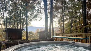 A hot tub surrounded by trees and a wooden deck. - Silver Linings - Hot Tub, Mountain Views, Close to Town, Pet Friendly (Waynesville)