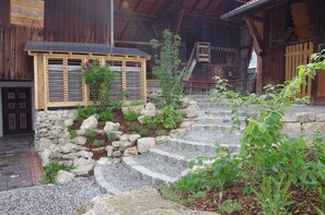 Ein rustikales Holzhaus mit einer Steintreppe, die zu einer Holztür führt.