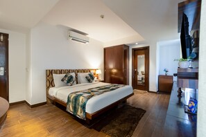 A modern bedroom with a large bed, wooden wardrobe, and a flat-screen TV. - Arch Plaza - Near Yashobhoomi Convention Centre Dwarka (New Delhi)