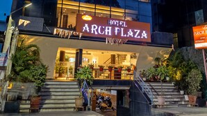 A hotel named 'ARCH PLAZA' with a modern facade, large windows, and a well-lit entrance. - Arch Plaza - Near Yashobhoomi Convention Centre Dwarka (New Delhi)