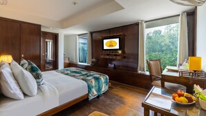 A hotel room with a large bed, a desk with a chair, a television, and a view of the outdoors. - Arch Plaza - Near Yashobhoomi Convention Centre Dwarka (New Delhi)