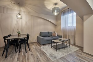 Uma sala de estar moderna com mesa de jantar, sofá e mesa de centro.