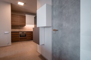 Cozinha moderna com armários de madeira, forno embutido e geladeira branca.