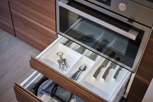 Uma gaveta de cozinha com utensílios e um abridor de garrafa.