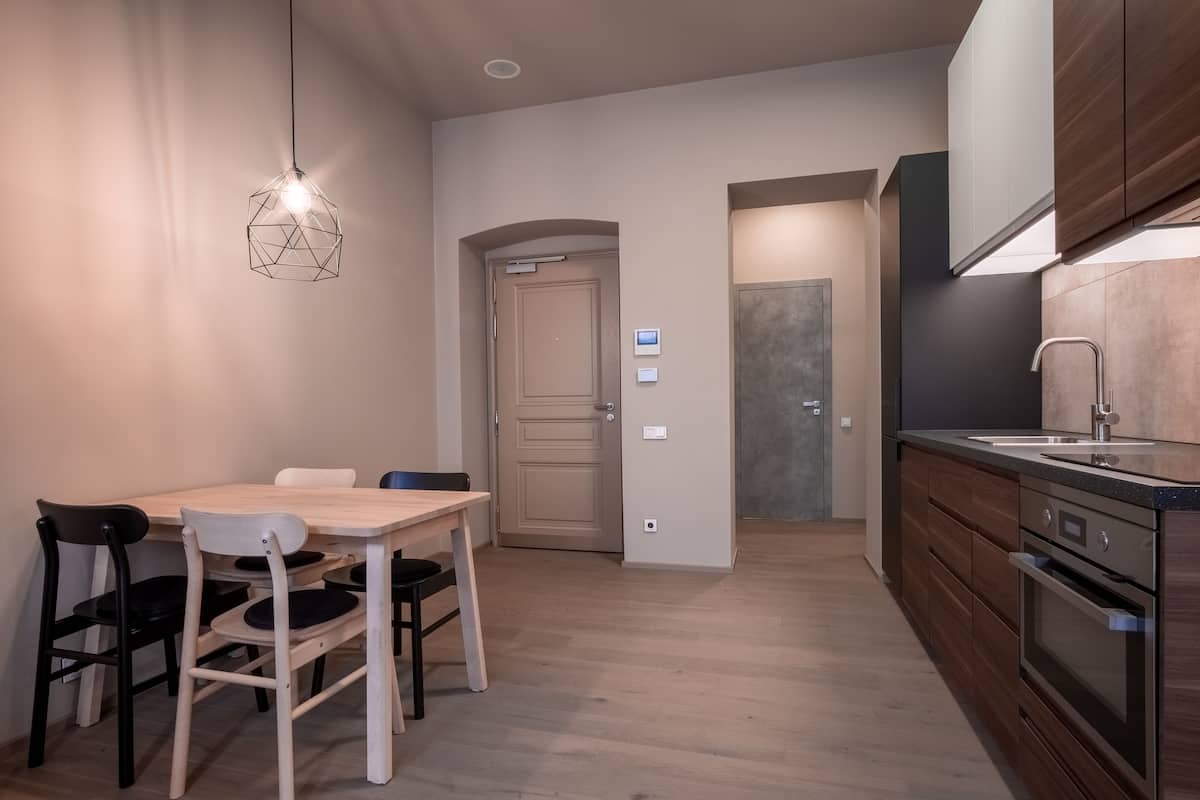 A modern kitchen with wooden cabinets, a built-in oven, and a countertop with a sink.