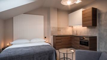 Un dormitorio moderno con una cama grande, una mesita redonda y un sofá.