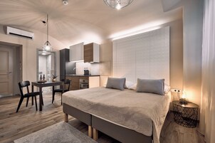 Um quarto moderno com uma cama grande, mesas de cabeceira, escrivaninha e uma cadeira.