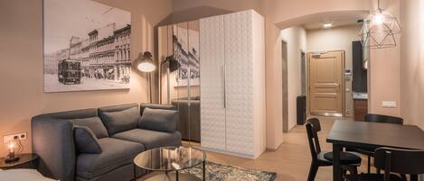 A modern living room with a sofa, coffee table, and dining area.