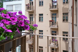 Um edifício com vários andares e varandas, algumas com vasos de flores.