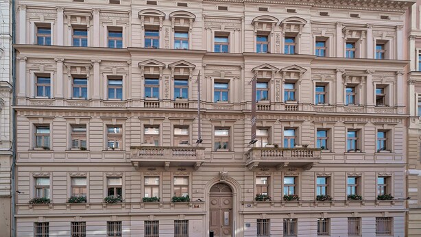 Un edificio de varios pisos con estilo arquitectónico clásico, que presenta ventanas simétricas y molduras decorativas.