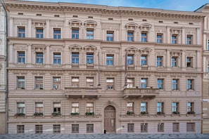 Un edificio de varios pisos con estilo arquitectónico clásico, que presenta ventanas simétricas y molduras decorativas.