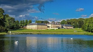 A large, historic building with multiple wings, situated by a calm lake with swans. - Hardwick Haven, Sedgefield - Near Hardwick Hall (Stockton-on-Tees)