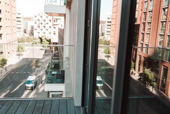 Overlooking the bustling city, this apartment offers a glass balcony with a view of the street below.