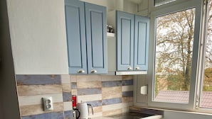 Uma cozinha moderna com armários azul-claros, bancada de madeira e forno embutido.