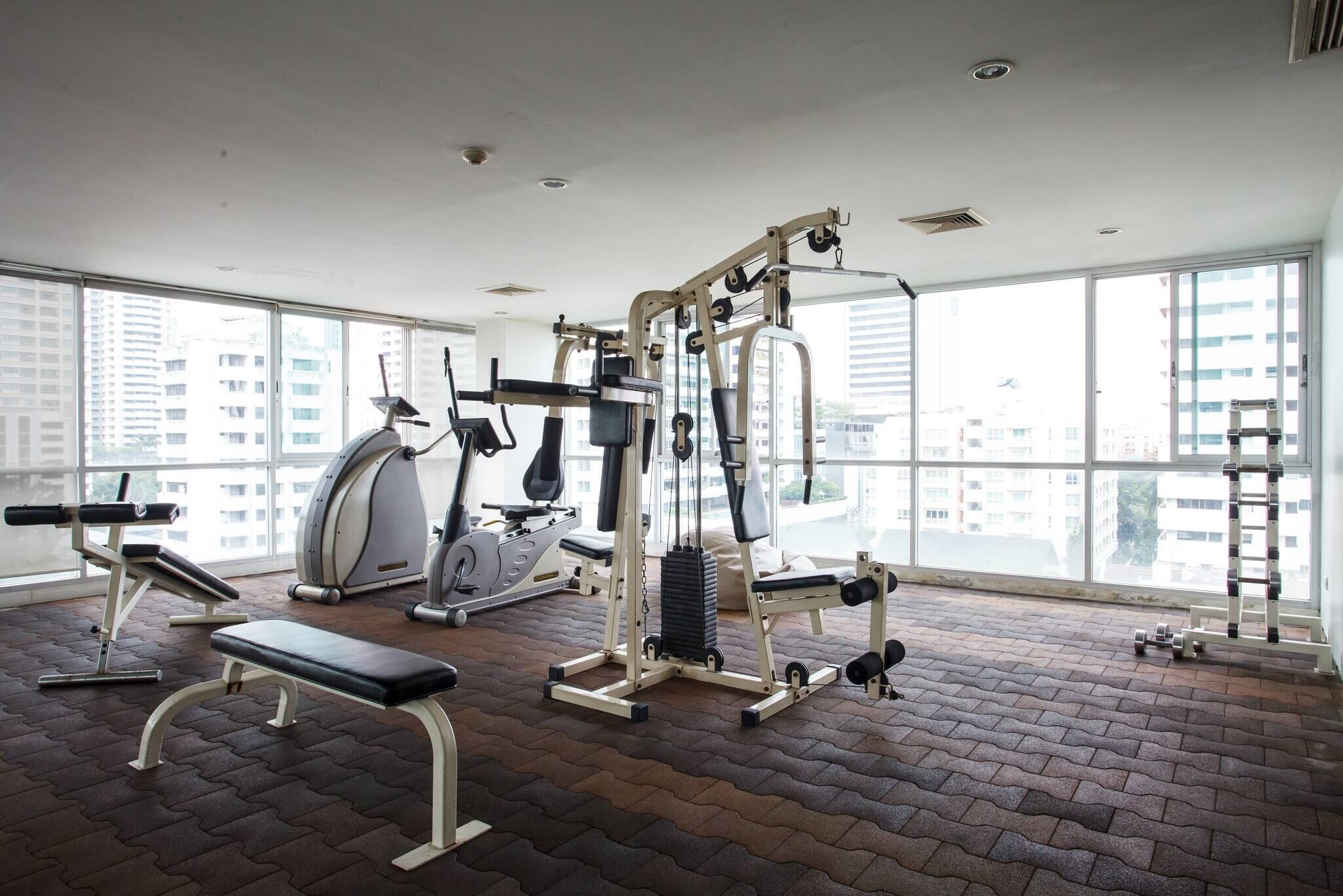 A gym with exercise equipment, a treadmill, and a bench.