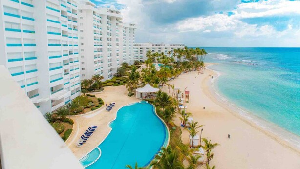 Un resort con piscina, playa y vista al océano.