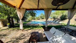 A covered outdoor seating area with a pool in the background. - Detached Villa - Sleeps 10 - Pool - Pergola - Playground for Children - Wifi (Todi)