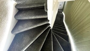 A spiral staircase with carpeted steps leading to a landing. - Luxury 3 Bedrooms Entire Flat - Self Check in & Check out (Cowdenbeath)