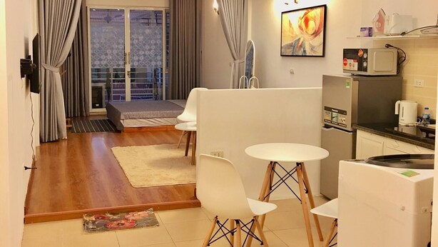A modern kitchen with a dining area, a microwave, a coffee maker, and a refrigerator. - Wind Chimes Hideaway - Apartment In Central Hanoi (Hanoi)